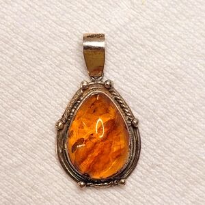 Amber teardrop necklace pendant set in silver toned metal